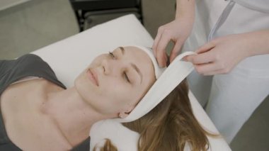 Kız, sakin bir kozmetoloji stüdyosunda kalıcı makyaj tedavisi görüyor.