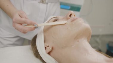 Uzman kız profesyonel güzellik salonunda kalıcı makyaj uygulaması yapıyor.