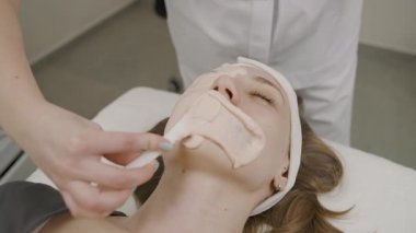 Modern bir stüdyo ortamında kozmetoloji salonunda kalıcı makyaj tedavisi gören bir kız.