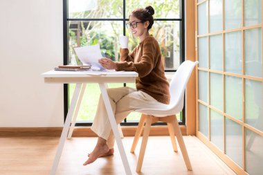 Gençler evde dizüstü bilgisayarla çalışır ve sabahları kahve içerler. Evde dinlenirler. Asyalı kadın toplantı konferansı ofisi internet üzerinden bağlıyor. İş ve Teknoloji Konsepti