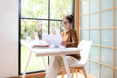 Gençler evde dizüstü bilgisayarla çalışır ve sabahları kahve içerler. Evde dinlenirler. Asyalı kadın toplantı konferansı ofisi internet üzerinden bağlıyor. İş ve Teknoloji Konsepti