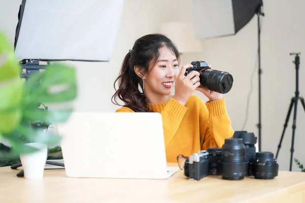 stock image Lifestyle Asia young women photographer and freelance holding a dslr camera in  home office.  Female photographer smiling cheerfully working new project in studio