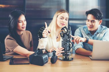 Grup çalışması programcısı ve mühendis yapay zeka robot kolu sistemi üzerinde çalışıyor. İş adamları üretim sürecini başlatma teknolojisi ve kol sistemi projesini inşa eden mantık kontrolü