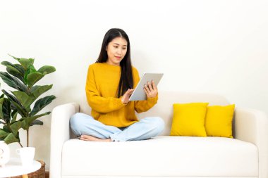 Mutlu genç bir kadın evde online alışveriş yapmak için akıllı telefon kullanıyor. Yaşam tarzı rahatlamak ve oturma odasında kahve içmek. Yaşam Tarzı Konsepti