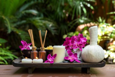 Tayland Spa Tedavileri aroma terapisi tuz ve şeker masajı. Sırt tahtasında mor orkide çiçeği ve mum var. Tayland. Sağlıklı Konsept