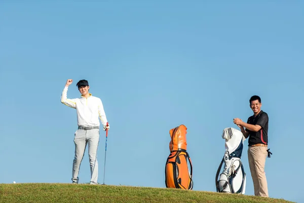 ゴルファースポーツコースゴルフボールフェアウェイ グループの人々のライフスタイルの男性と友人は 緑の芝生の上でオフにゲームゴルフティーをプレイ アジアの男性選手ゲームは夏に撮影 — ストック写真