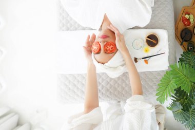 Arkadaş kız yüzünü domatesle maskelemeye yardım eder ve spa suratlı kadın tedavisi ve masaj aroma terapisi rahatlatıcı ve sağlıklı ve güzel. Vücut ve yüz için Tayland spa terapi tedavisi
