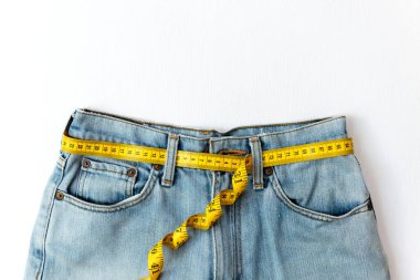 Sağlıklı beslenmeyi planlıyorum. Diyet sağlığı için bel çevresindeki bandı ölçün. Sağlıklı Yaşam Tarzı Konsepti. Beyaz arkaplan. Metin için Üst Görünüm ve Kopyalama alanı