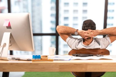 İş adamı Kafkasyalı sıkı çalıştıktan sonra dinleniyor. Modern ofisteki finansal veriler üzerinde çalışan ve analiz yapan adam işten sonra dinleniyor. İş Konsepti
