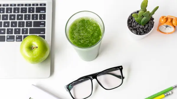 Healthy snack with working in office.  Green apple and fresh water for diet Health Planning, laptop work background.  Healthy Lifestyle Concept