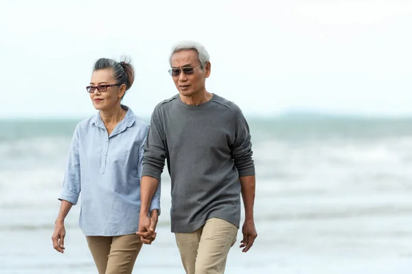 Asian Lifestyle senior couple walking chill on the beach happy in love romantic and relax time after retirement. People tourism elderly family travel leisure and activity