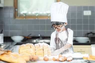 Yemek pişiren aile. Aşçı çocuk tost yapmayı ve babasıyla ekmek yapmayı seviyor. Asyalı oğul, babaya tatlı yemek ve eğitim konusunda yardım ediyor. Aile Yaşam Tarzı Konsepti