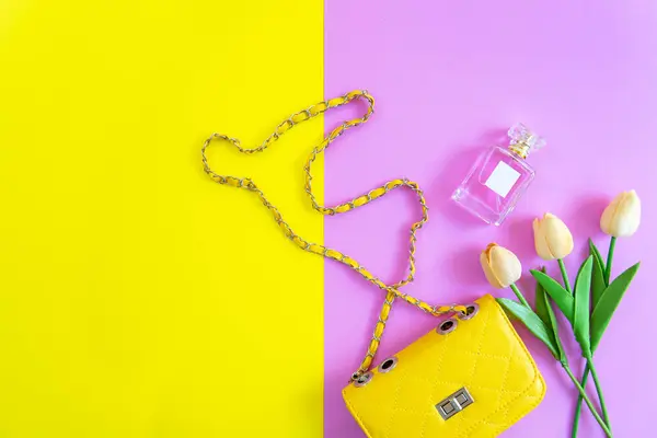 Fashion stylish yellow bag and woman accessories pastel background. Trendy fashion luxury handbag, perfume and cosmetic design. Lifestyle and Beauty Concept