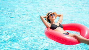 Yaz zamanı ve tatiller. Rubber yüzüklü kadın yaşam tarzı. Lüks yüzme havuzunda rahatlıyor ve mutlu. Oteldeki tatil köyünde yaz günü. Yaz Konsepti