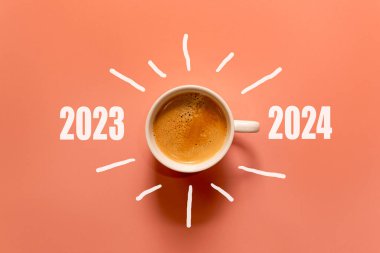 Mutlu yıllar ve Mutlu Noeller 2024. Kahve fincanını değiştir ve 2023 'ten 2024' e kadar turuncu arka plandan indir. Başlangıç ve Yeni Yıl Konsepti. Boşluğu kopyala 