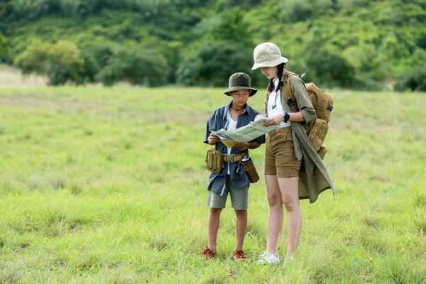 Group family children checking map in the jungle adventure.   Asia people tourism for destination leisure trips for education and relax in nature park.  Travel vacations and Life Concept