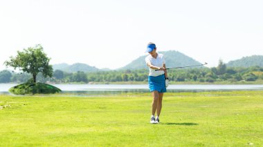 Golf sahası golf sahası sahası. İnsanlar golf topunu yeşilde salladıktan sonra rahatlıyor. Asya 'lı bayan oyuncu yazın vuruldu. Sağlıklı ve Spor açık hava, metin için alanı kopyala