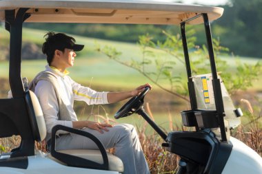 Golf sahasında oturan Asyalı golfçü. Golf sahasına git. Devam et. Tatilde hobi, güneşli bir sabahta golf kulübünde tatil. Yaşam Tarzı ve Spor Konsepti