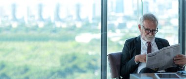 İş ortağı yönetici akıllı adam restoranda oturuyor ve gazete okuyor. Yaşlı işadamı zamanı görür ve iş için eşinizi bekler. İş Konsepti, afiş için kopyalama alanı