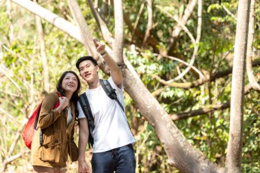 Turist ve gezgin Asyalı çift sırt çantası orman orman doğa parkının keyfini çıkarıyor ve mutlu. Gezgin kampa gidiyor ve gezintiye çıkıyor.