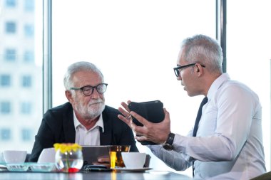 İş ekip çalışması toplantısı ve şimdiki zaman yeni bir proje başlatın. İnsanlar, modern ofise yatırım yapılması için mali destek grafiğini tartışıyor. Şehir geçmişi. İş ve Takım Çalışması Konsepti