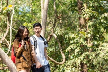 Turist ve gezgin Asyalı çift sırt çantası orman orman doğa parkının keyfini çıkarıyor ve mutlu. Gezgin kampa gidiyor ve gezintiye çıkıyor.