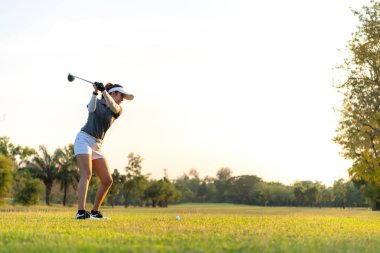 Golfçü kadınlar golf sahasında. İnsanların yaşam tarzı golf oynayan bir kadın yeşil çimlerin üzerinde golf oynuyor. Yazın Asyalı bayan oyuncu vuruşu. metin için boşluk kopyala