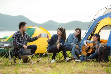 Dışarıda kamp var. Grup arkadaşlar kamp eğlence ve hedef seyahat. Aile kamp ateşi etrafında oturan ve gitar ve kavrulmuş sosis oynarken, turizm dinlenmek ve tatil nehir yakınında seyahat.