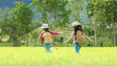 Grup çocukları orman macerasında haritayı kontrol ediyor. Asyalılar eğitim için tatil gezileri için turizm yapıyor ve doğa parkında dinleniyor. Dağ arka planı