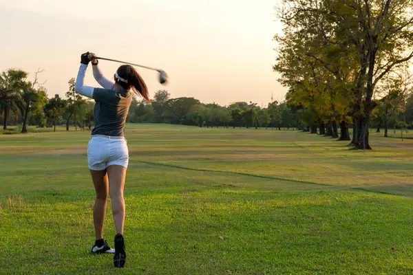 Golfçü kadınlar golf sahasında. İnsanların yaşam tarzı golf oynayan bir kadın yeşil çimlerin üzerinde golf oynuyor. Yazın Asyalı bayan oyuncu vuruşu. metin için boşluk kopyala