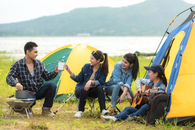 Dışarıda kamp var. Grup arkadaşlar kamp eğlence ve hedef seyahat. Aile kamp ateşi etrafında oturan ve gitar ve kavrulmuş sosis oynarken, turizm dinlenmek ve tatil nehir yakınında seyahat.