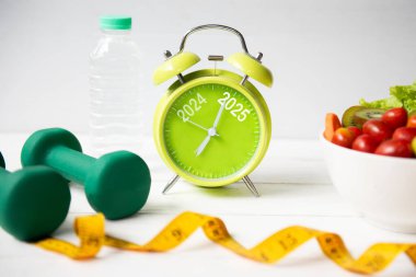 2025 ve 2024 alarmlı saat ve diyet için egzersiz planı. Spor aletleri, spor aletleri ve spor salatası. Spor için taze salata. Mutlu Noeller ve mutlu yıllar.