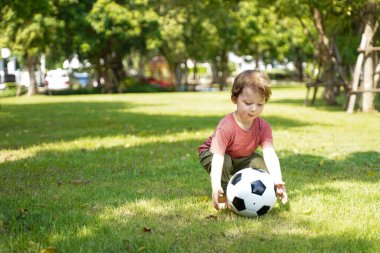 Yaz tatilinde parkta futbol oynayan mutlu çocuk. Aile rahatlar ve dışarıda eğlenir. Aile ve Yaşam Tarzı Kavramı