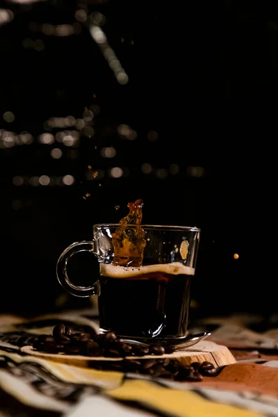 glass of coffee with drops falling