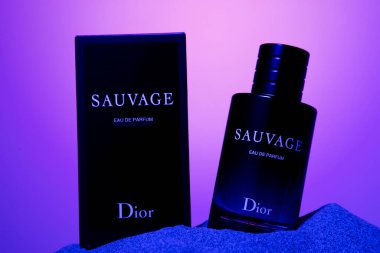 SAUVAGE eau de parfum, desert sand cologne bottle, blue and viol