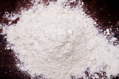 Mountain of fresh flour on a wooden table, basic ingredient for 