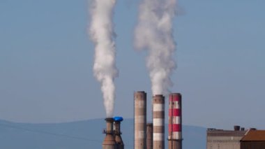 Endüstriyel tesislerin bacalarından çıkan ve çevreyi kirleten zehirli atık ve duman görüntüleri.