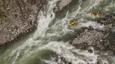 Rafting sporunun yüksek akışlı, azgın bir nehirde çekilmiş görüntüsü.