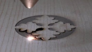 Tahtaya CNC lazer makinesiyle kazınmış geleneksel motifler. Tahtaya oyma motifleri için bilgisayar kontrollü cnc lazer makinesi resmi.