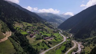Çam ormanlarındaki ağaçların arasında yer alan dağ köyleri ve yaylaların görüntüleri.