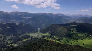 Çam ormanlarındaki ağaçların arasında yer alan dağ köyleri ve yaylaların görüntüleri.