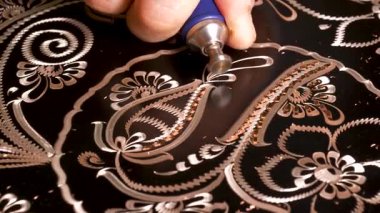 El sanatları. Bakıra çeşitli aletlerle işlenmiş geleneksel motifler, bakır süs sanatı. Bakıra göz alıcı desenler kazınıyor.