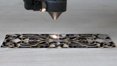 Tahtaya CNC lazer makinesiyle kazınmış geleneksel motifler. Tahtaya oyma motifleri için bilgisayar kontrollü cnc lazer makinesi resmi.