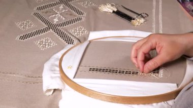 Geleneksel motifler, ahşap bir çemberin üzerine işlenmiş kumaşa işlenmiş. Etkileyici görünümlü ve renkli ipliklerle yapılmış el sanatları..