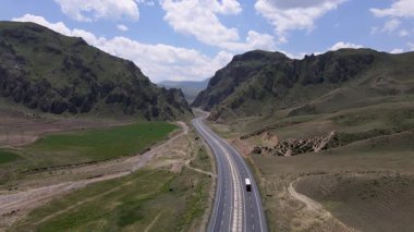 Dağlardan geçen, vadiden geçen ve şehirlerarası ulaşımı sağlayan yolun görüntüleri..