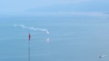 Bombalar atıp duman çıkaran ve akrobatik hareketler yapan savaş uçağının gösterisi..