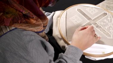 Geleneksel motifler, ahşap bir çemberin üzerine işlenmiş kumaşa işlenmiş. Etkileyici görünümlü ve renkli ipliklerle yapılmış el sanatları..