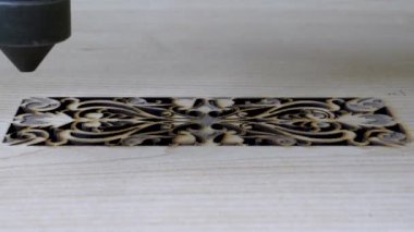 Tahtaya CNC lazer makinesiyle kazınmış geleneksel motifler. Tahtaya oyma motifleri için bilgisayar kontrollü cnc lazer makinesi resmi.