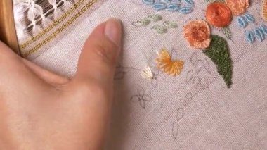Geleneksel motifler, ahşap bir çemberin üzerine işlenmiş kumaşa işlenmiş. Etkileyici görünümlü ve renkli ipliklerle yapılmış el sanatları..