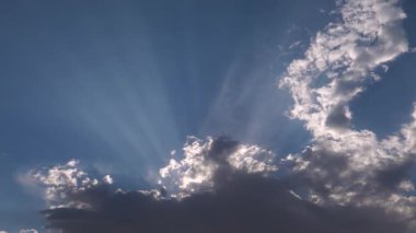 Yağmur ve fırtına bulutlarıyla kaplı kasvetli bir gökyüzünde, bulutların arasındaki ışık demetlerinin zamanlanmış görüntüleri..